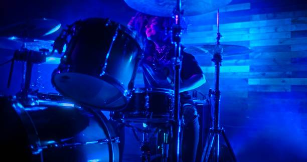 istock Professional Drummer emphatically playing the drums in twinkling blue lights 1388939008