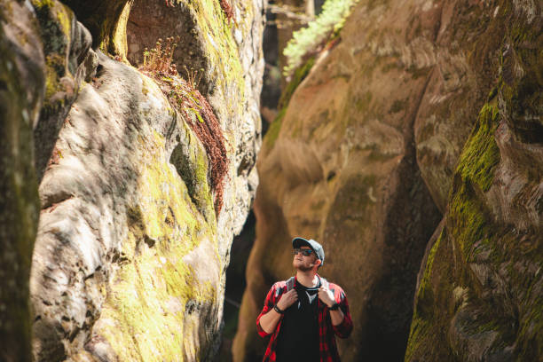 man hiker with backpack walking by trail in canyon dovbush rocks Ukraine