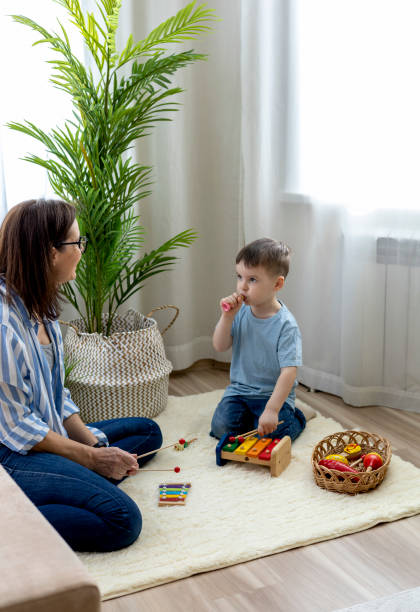 istock Montessori material. Home education. Mom and son are learning musical instruments. 1388943227