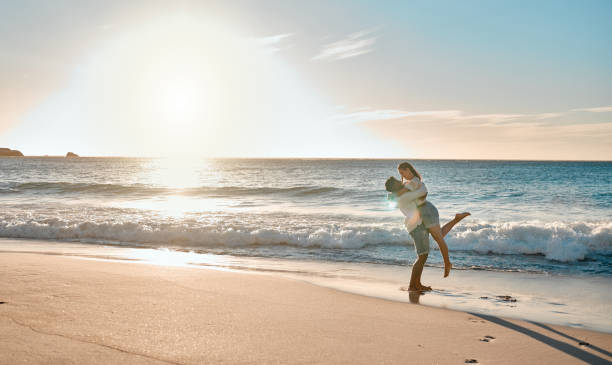 scatto di una giovane coppia che trascorre del tempo insieme in spiaggia - honeymoon foto e immagini stock