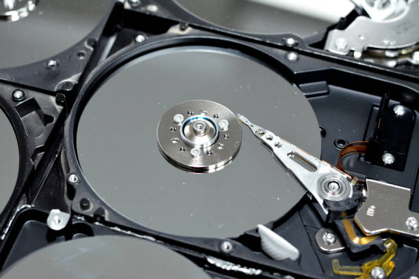 istock Computer hard disk drive storage memory, repair broken computer part, close up of open hard disc with platters, spindle, actuator and read, write head 1388943784