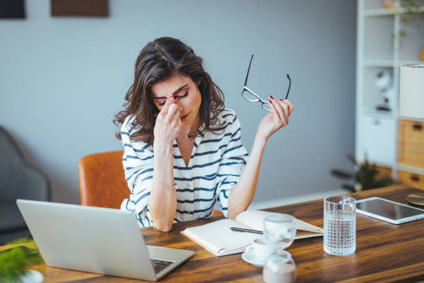 istock Shot of a young woman suffering from stress while using a computer at her work desk. 1388944534