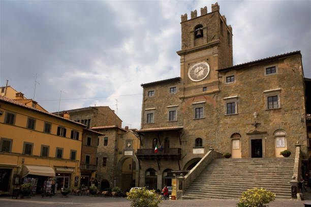 Piazza della Repubblica, Cortona, Arezzo, Tuscany, Italy, with the 13th century Palazzo Communale presiding The main square ( Piazza della Repubblica) in the medieval city of Cortona, called "the most romantic square in Italy".  It is dominated by the 13th century Palazzo Comunale, recognizable by the tower with the clock and the grandiose access staircase. cortona stock pictures, royalty-free photos & images