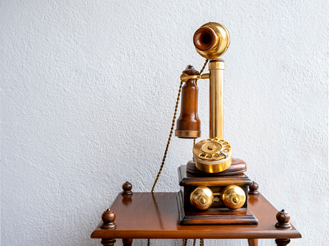 antique telephone in front of white wall