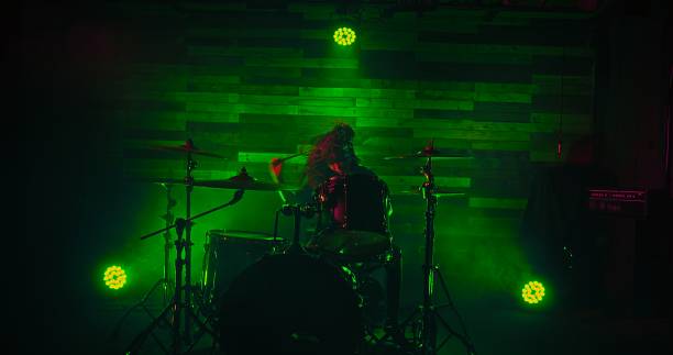 istock Professional drummer playing on stage during rock show in green spot lights 1388947002