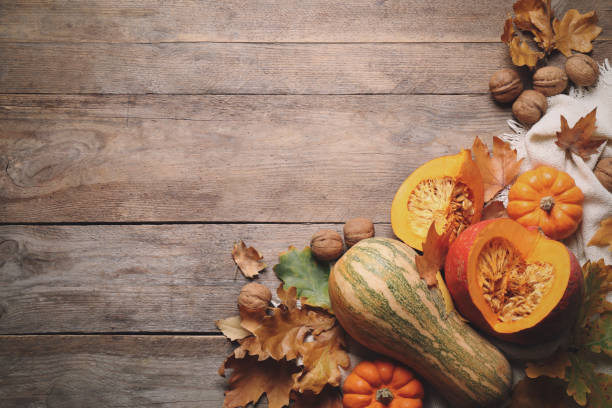 istock Flat lay composition with vegetables, nuts and autumn leaves on wooden table, space for text. Thanksgiving Day 1388947386