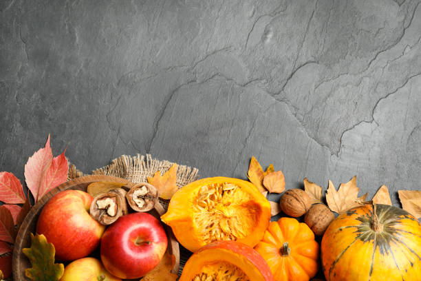 istock Flat lay composition with vegetables, fruits and autumn leaves on black slate table, space for text. Thanksgiving Day 1388947433