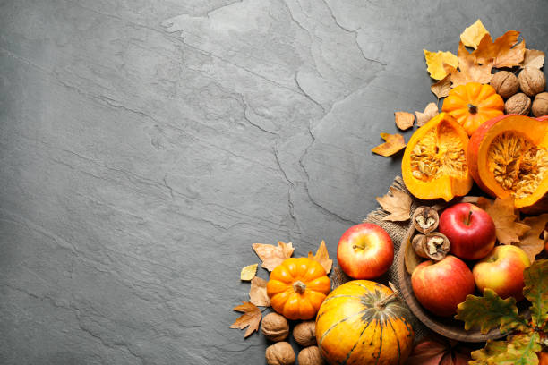 istock Flat lay composition with vegetables, fruits and autumn leaves on black slate table, space for text. Thanksgiving Day 1388948379