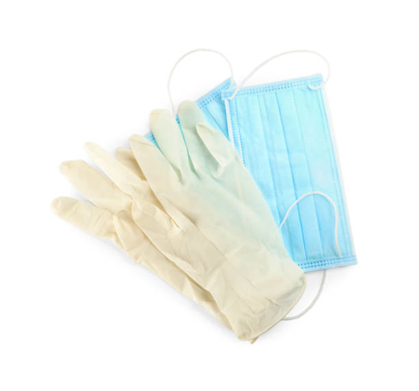 istock Medical gloves and protective face masks on white background, top view 1388948499