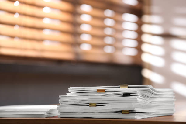 istock Stack of blank paper with binder clips on wooden table indoors. Space for text 1388950125