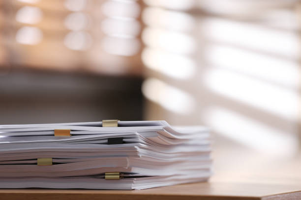 pile de papier vierge avec des clips de reliure sur une table en bois à l’intérieur. espace pour le texte - document photos et images de collection