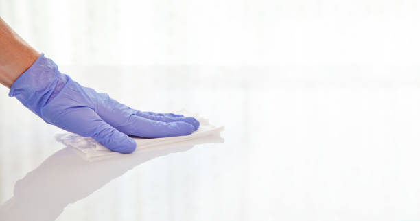 Surface disinfecting home cleaning with sanitizing antibacterial wipes protection against COVID-19 spreading wearing medical blue gloves. Sanitize surfaces prevention in hospitals and public spaces surface disinfection stock pictures, royalty-free photos & images