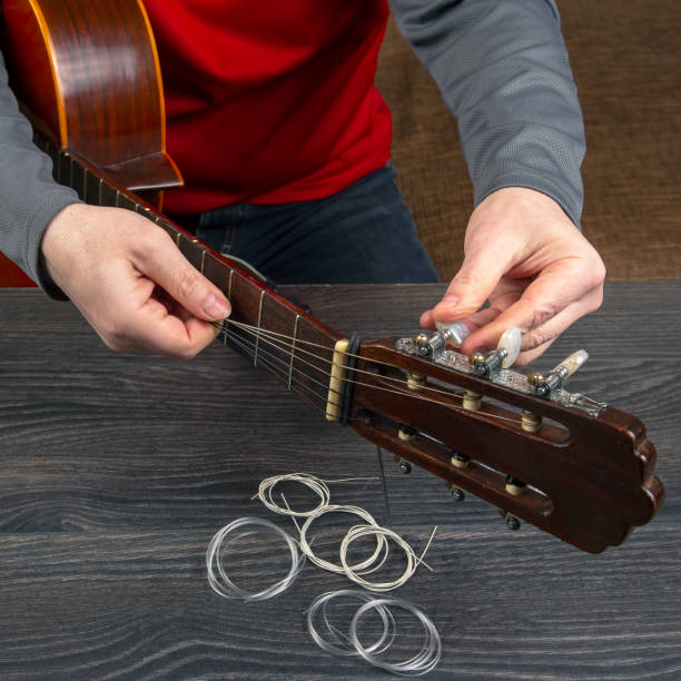 istock replacement and insertion of nylon strings in a classical guitar. lesson for a musician 1388952667