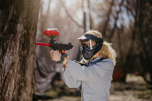 Young woman in full gear playing paintball