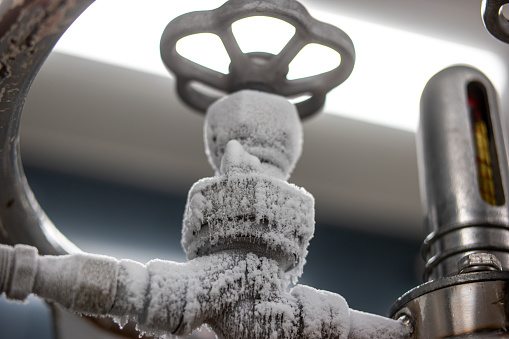 Frozen liquid nitrogen storage tank transfer valve. Close up shot, no people.