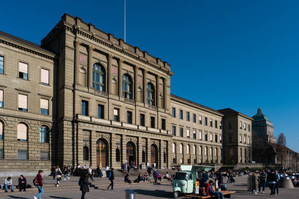 ETH University Zurich, Switzerland. Daytime, blue sky, wide angle view. Students enjoying their break sitting outside.