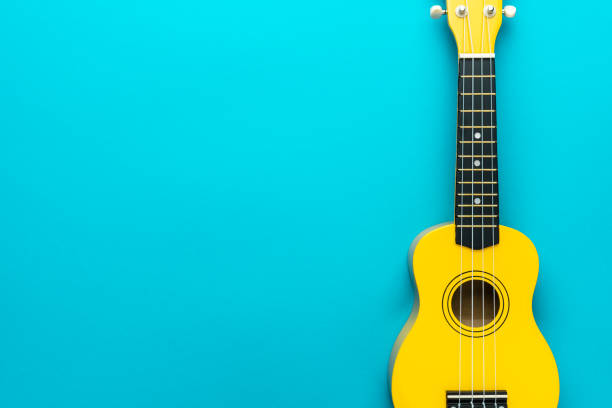 Flat lay photo of yellow ukulele with copy space