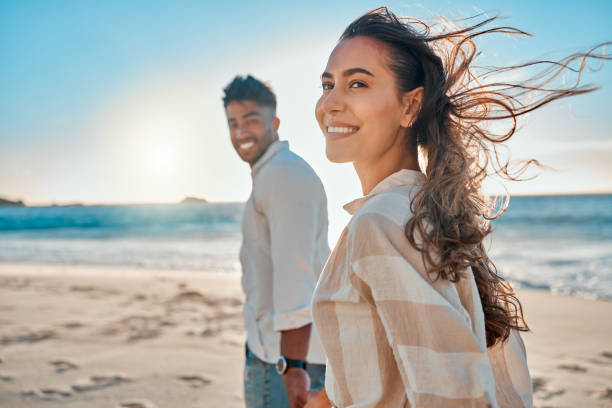 scatto di una giovane coppia che trascorre del tempo insieme in spiaggia - couple loving married affectionate foto e immagini stock