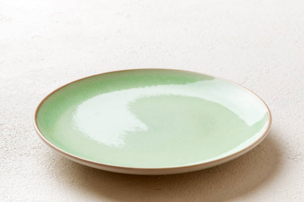 istock Perspective view of empty green plate on cement background. Empty space for your design 1388958379