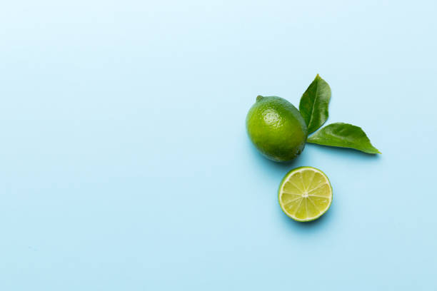 istock Lime fruits with green leaf and cut in half slice isolated on white background. Top view. Flat lay with copy space 1388958978