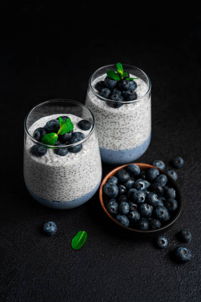 istock Chia pudding with blueberries on a dark background. Chia pudding, mint and blueberries on a black background 1388959090