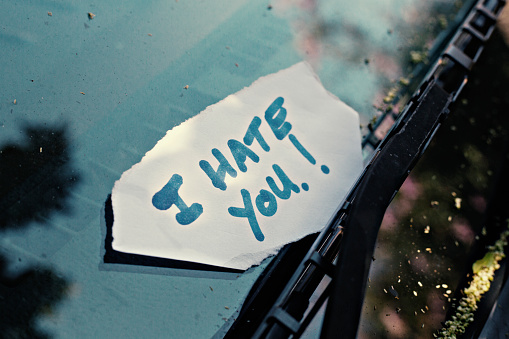 Notes placed under windshield wiper of car with the words I have you