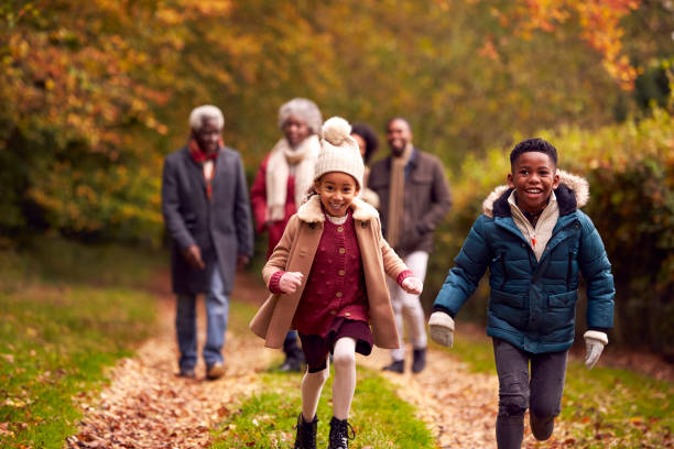 istock Smiling Multi-Generation Family Having Fun Walking Through Autumn Countryside Together 1388962691