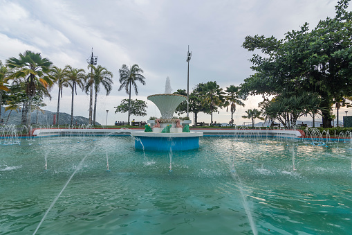 Santos city, Brazil, March 30, 2022: Frog Fountain in the beach gardens of the city and the waterfront buildings.
