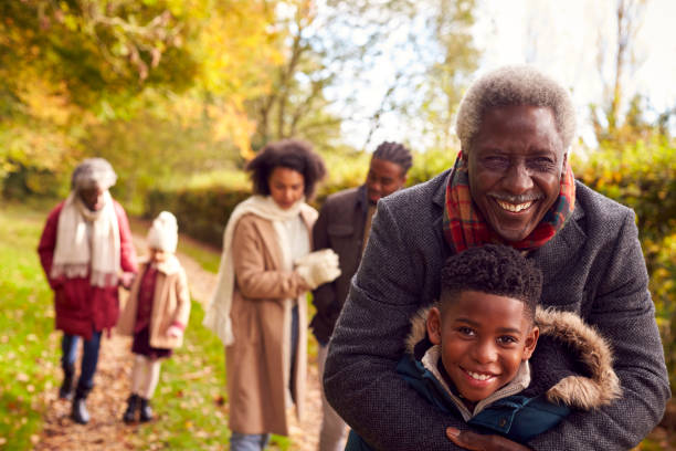 istock Smiling Multi-Generation Family Having Fun Walking Through Autumn Countryside Together 1388963900