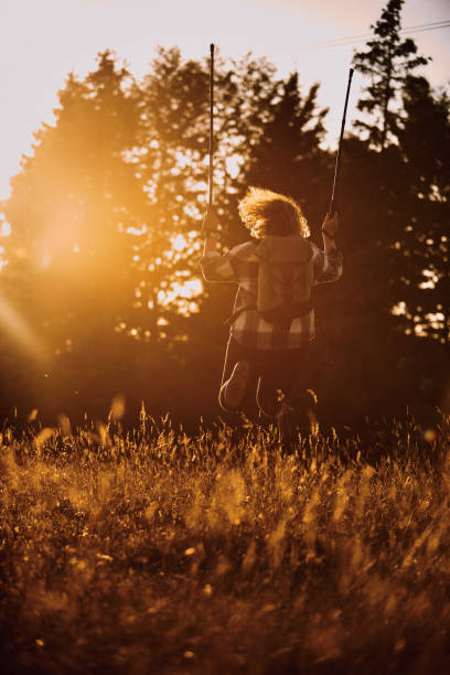 A woman hiking with a backpack and poles at sunset. Selective focus. High-quality photo