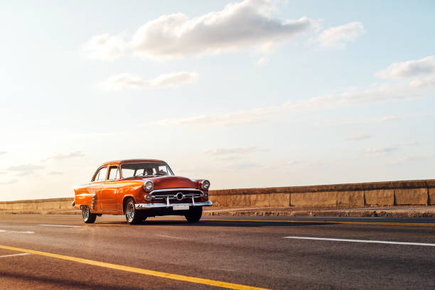 voiture rouge vintage au coucher du soleil sur el malecon, la havane - taxi retro revival havana car photos et images de collection