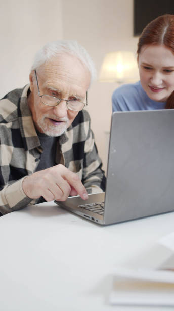 istock Woman volunteer helping elderly and sick man use video call 1388965806