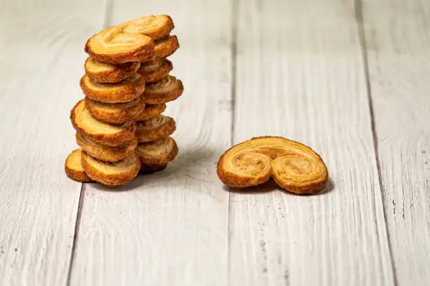 Palmier puff pastry biscuits on a white wooden table