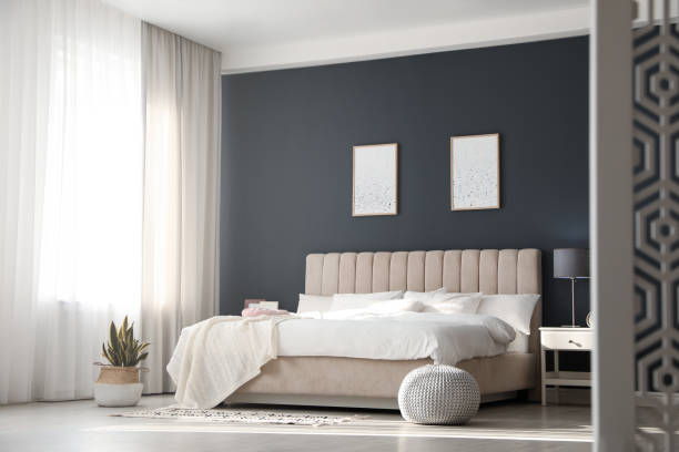 istock Comfortable bed with soft blanket in stylish room interior 1388967581