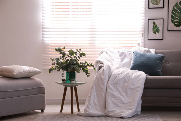 istock Comfortable sofa with blanket in stylish room interior 1388967671
