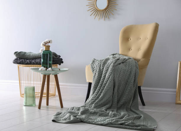 istock Soft knitted blanket on armchair in room. Home interior 1388967740