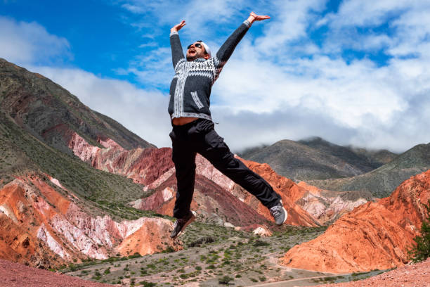 Happy jumping man in Purmamarca, Jujuy, Argentina Happy jumping man in Purmamarca, Jujuy, Argentina. Man on vacation in Argentina. North of Argentina. jumping man. Hill of seven colors, Purmamarca argentinian ethnicity stock pictures, royalty-free photos & images