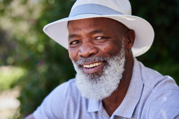 istock Smiling mature man sitting outside on a sunny afternoon 1388968436