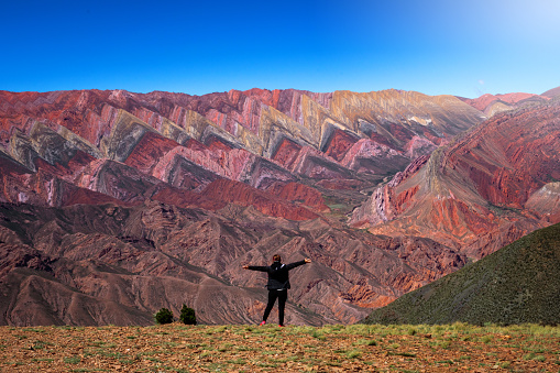 Selective Focus. The Hornocal, Jujuy Argentina. Hill of fourteen colors. Happy person in El Hornocal. person posing from behind in El Hornocal. Beautiful landscape of Argentina