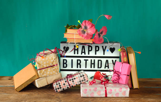 gift-wrapped books as birthday present, sign with lettering happy birthday and decoration. Reading,literature,education,gift,present,birthday concept. stock photo