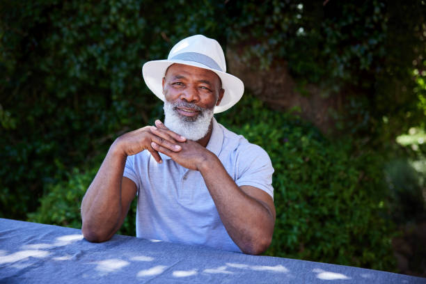 istock Stylish mature man sitting at a table outside in summer 1388968834