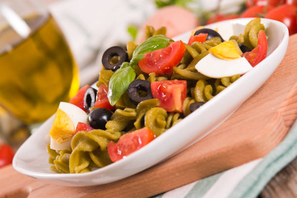 Fusilli pasta with cherry tomatoes, eggs and black olives.