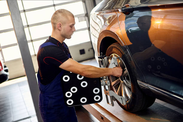 istock uto mechanic sets the car for diagnostics and configuration collapse-convergence. Car Wheels alignment equipment on stand in a repair station. 1388970068