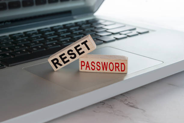 Reset password text on wooden block cube placed on laptop or notebook. stock photo