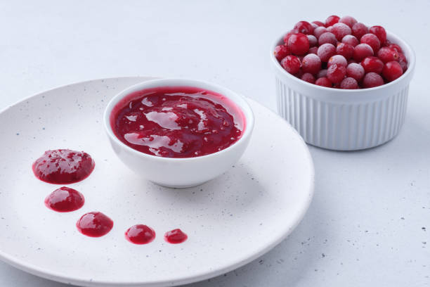 свежий органический клюквенный соус и клюква на белом фоне рамекина. - cranberry sauce стоковые фото и изображения