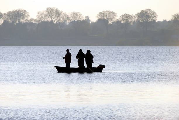 Lublin, Poland - April 2020: Fishermen on a boat at sunset