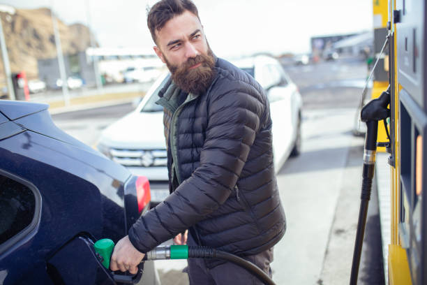 istock A hipster man refueling his car at a gas station. ISL 1388971781