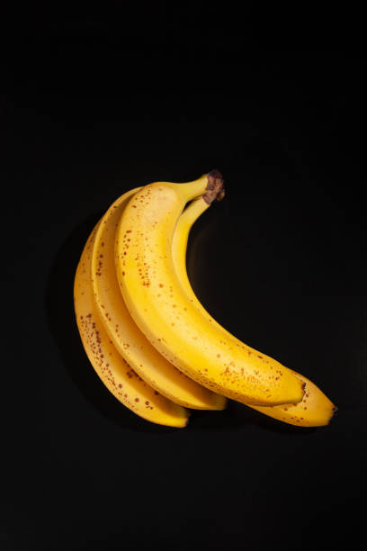 istock Bananas with few brown spots on dark background 1388972287