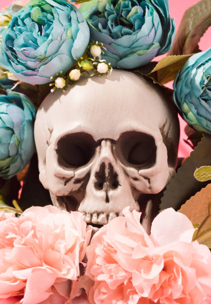 istock Human skull surrounded with teal and pink flowers. 1388974836