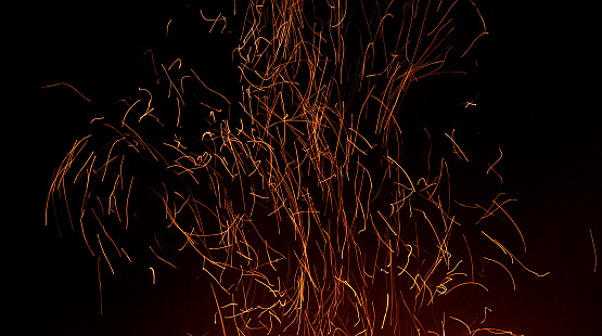 Abstract background of orange smoke and fire in the rays of the sun, beautiful glowing waves from the air with particles of energy and magic. Screensaver.